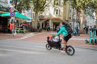 muli cycles compact electric cargo bike transporting 2 kids to school
